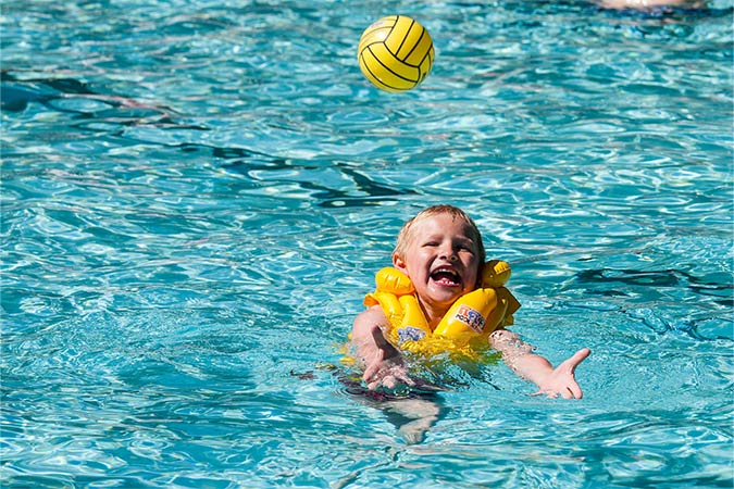 enfant jouant au ballon dans l'espace aquatique